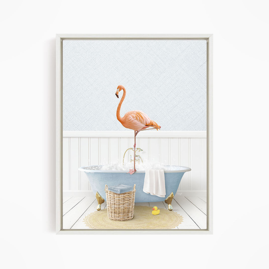 A pink flamingo stands on the edge of a blue clawfoot bathtub, surrounded by a yellow rubber duck, a woven basket, and a white towel.