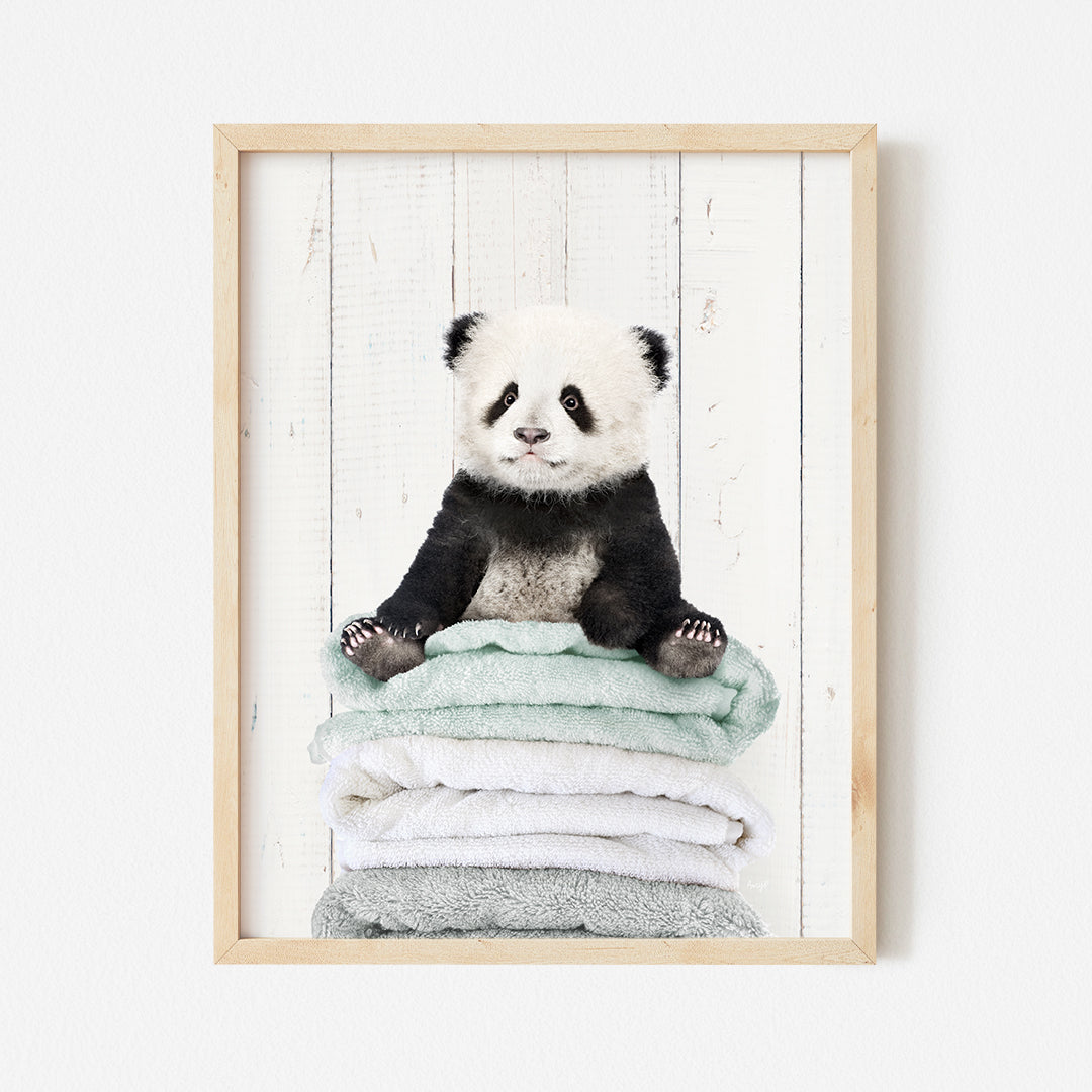 a panda bear sitting on top of a pile of towels