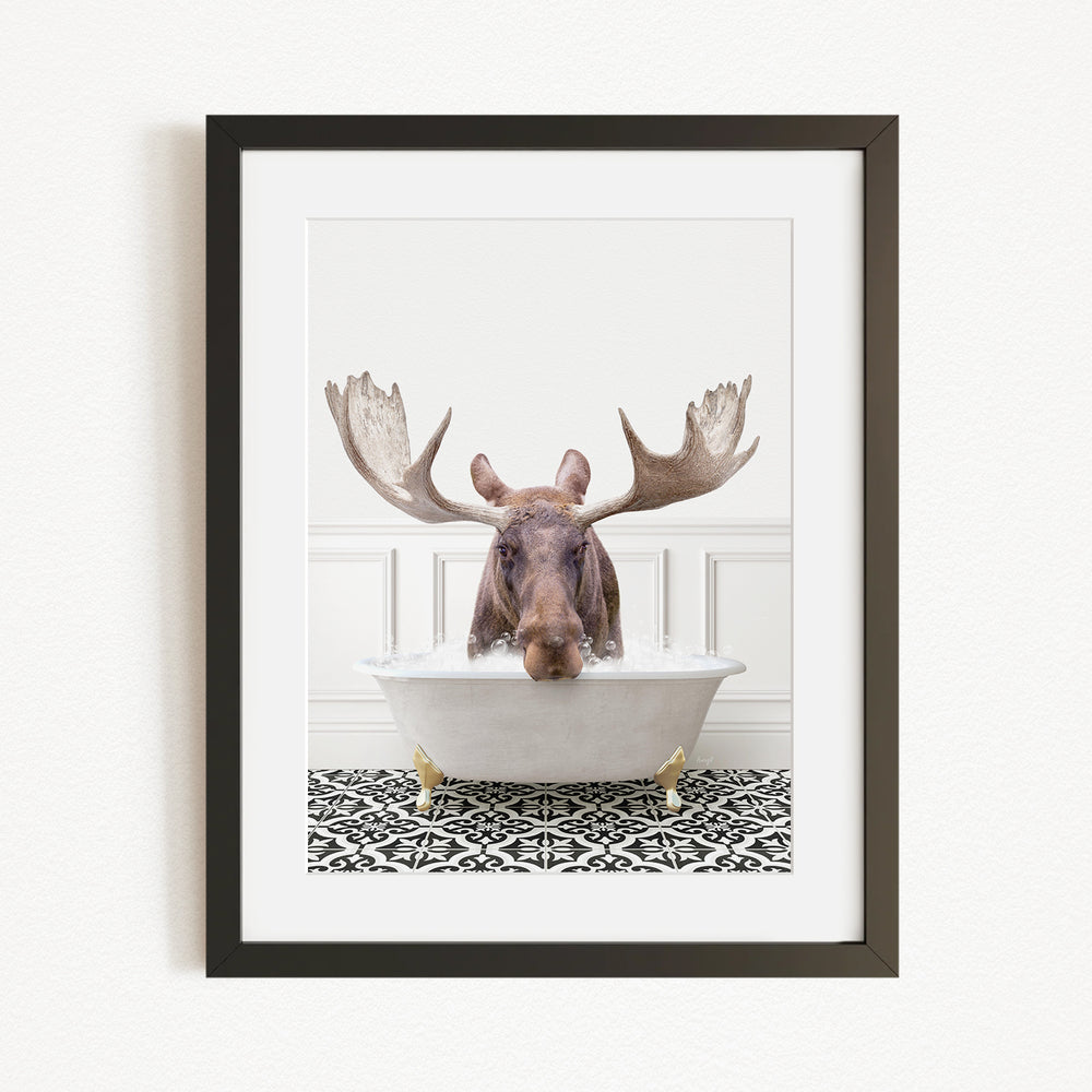 A moose with large antlers is sitting in a bathtub filled with water, creating a whimsical and humorous scene.