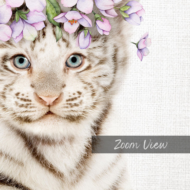 A close-up portrait of a white tiger cat with striking blue eyes, adorned with a floral headpiece of purple flowers.
