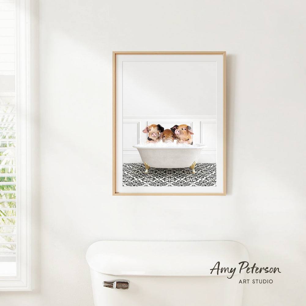 A framed image of three small animals, likely dogs, sitting in a bathtub in a bathroom setting.