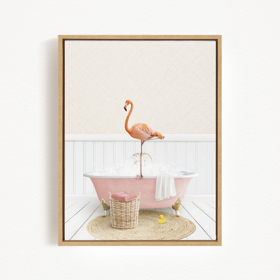 A pink bathtub filled with bubbles, with a flamingo standing on the edge and a basket of bath toys nearby.