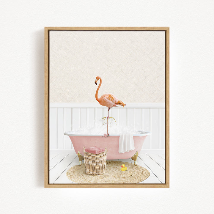 A pink bathtub filled with bubbles, with a flamingo standing on the edge and a basket of bath toys nearby.