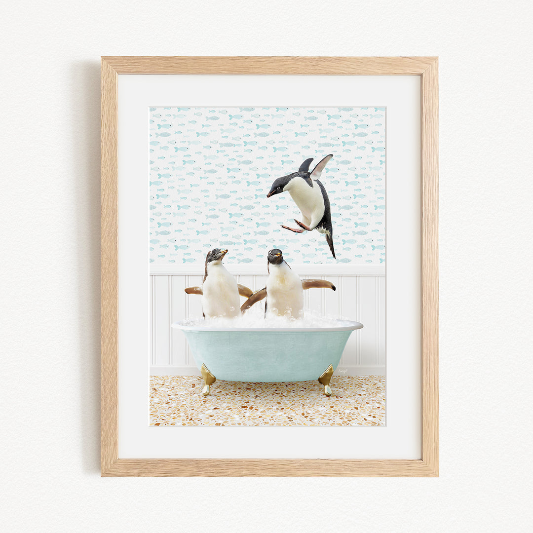A framed image depicting two penguins sitting in a bathtub, with one penguin flying towards the other.