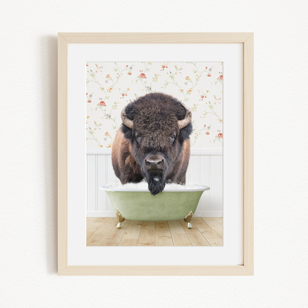 A buffalo standing in a green bathtub, with a floral wallpaper in the background.