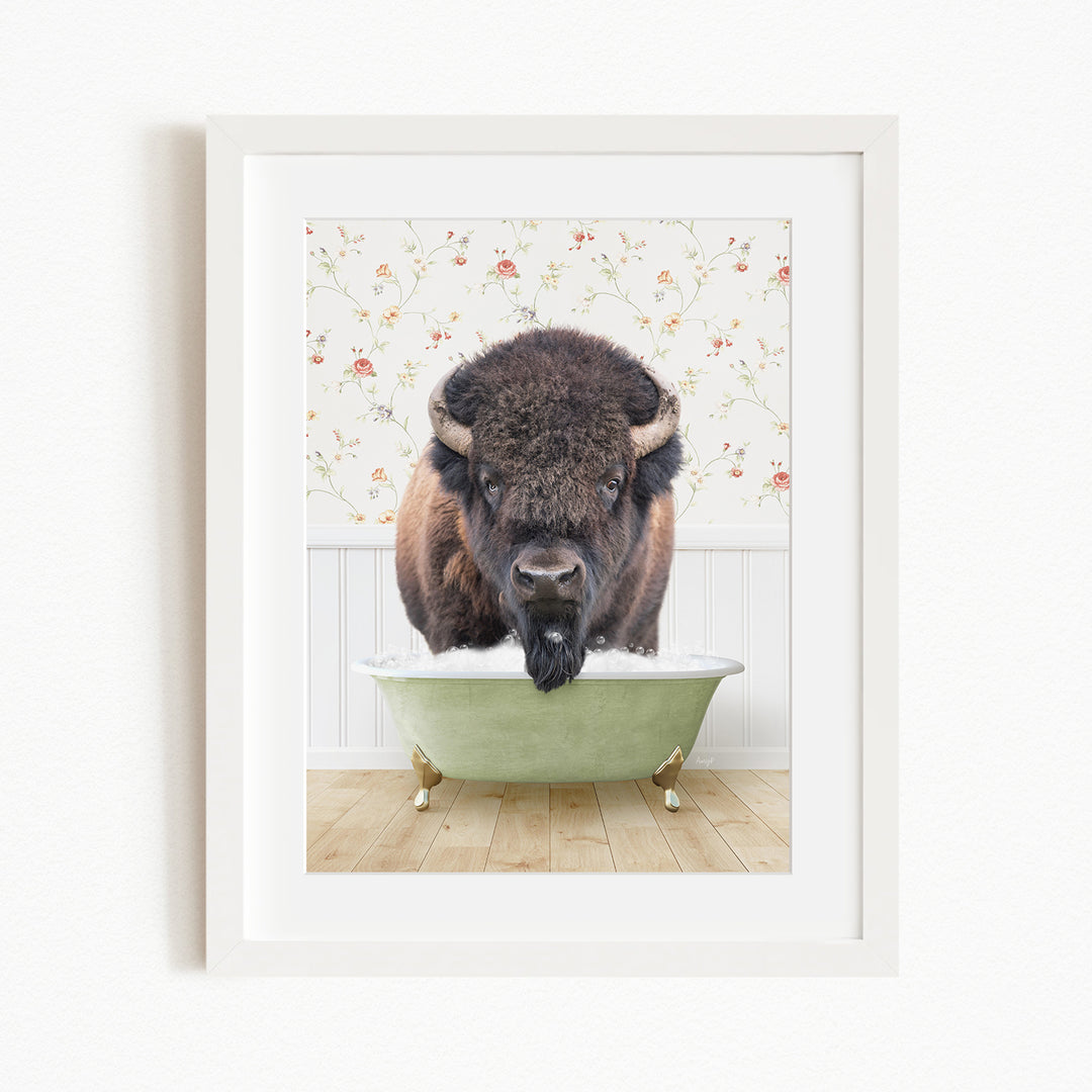 A buffalo standing in a green bathtub filled with water, with a floral wallpaper in the background.