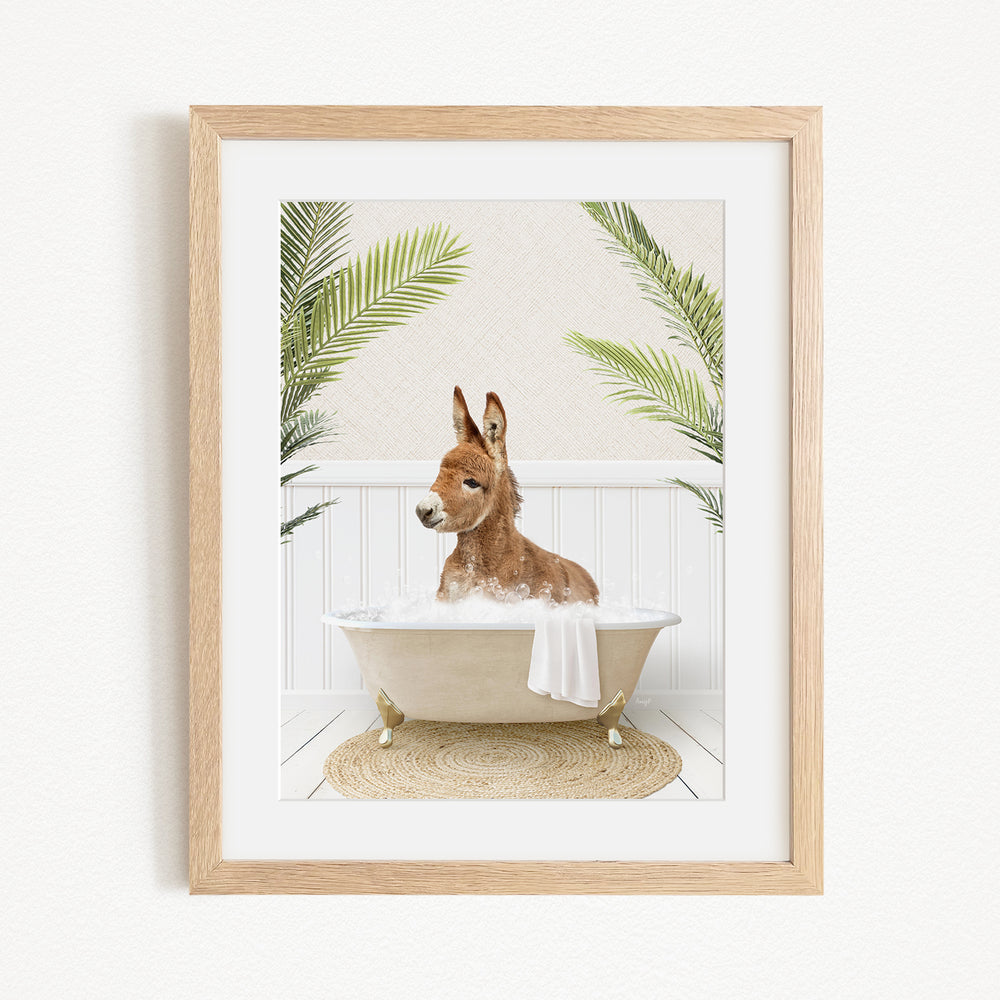 A donkey is sitting in a bathtub filled with water, surrounded by palm leaves, creating a whimsical and playful scene.