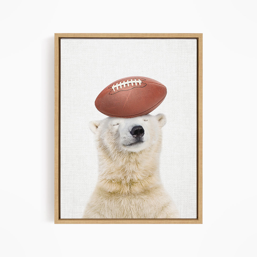 A polar bear balancing a football on its head.