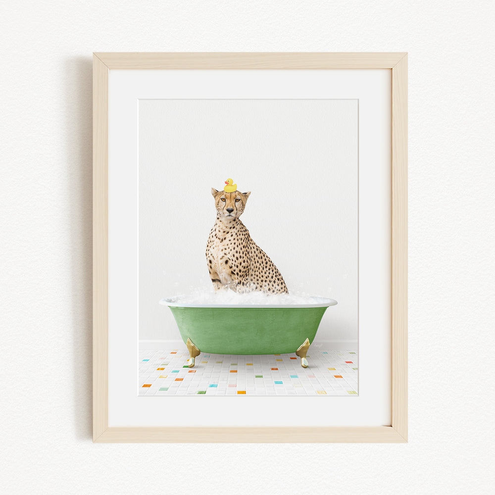 A cheetah sitting in a green bathtub filled with water, wearing a yellow hat.
