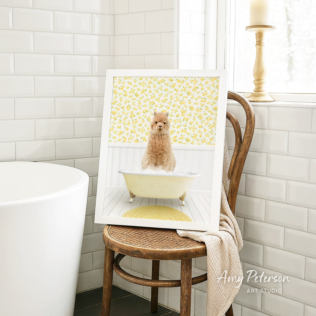 A framed image of a small dog sitting in a bathtub, surrounded by yellow flowers, is displayed on a wooden chair in a bathroom setting.
