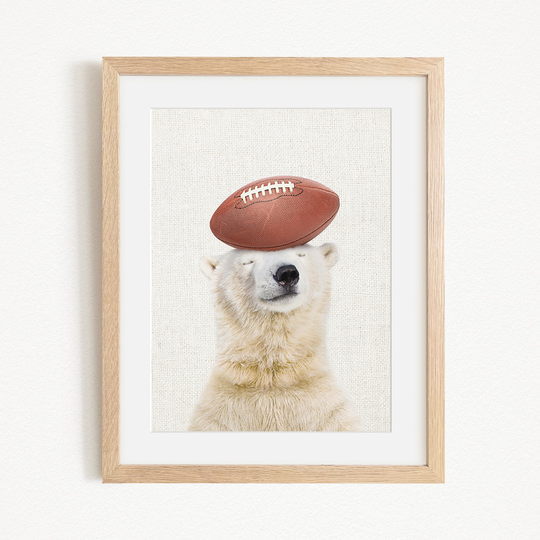 A polar bear wearing a football helmet and balancing the ball on its head.