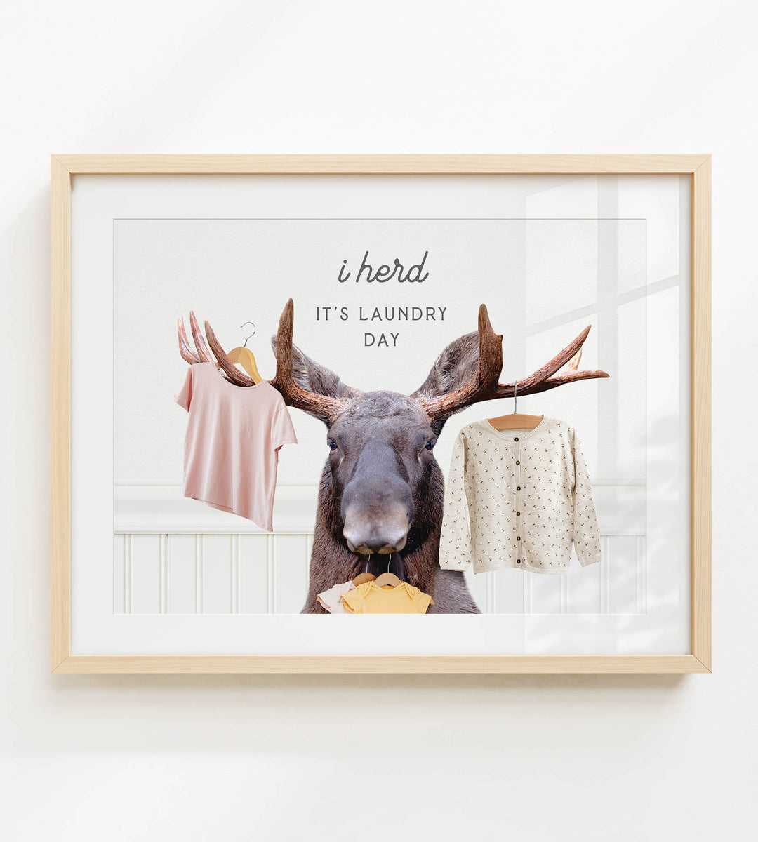 A framed collage of a moose holding clothes, with the text "It's laundry day" above it.