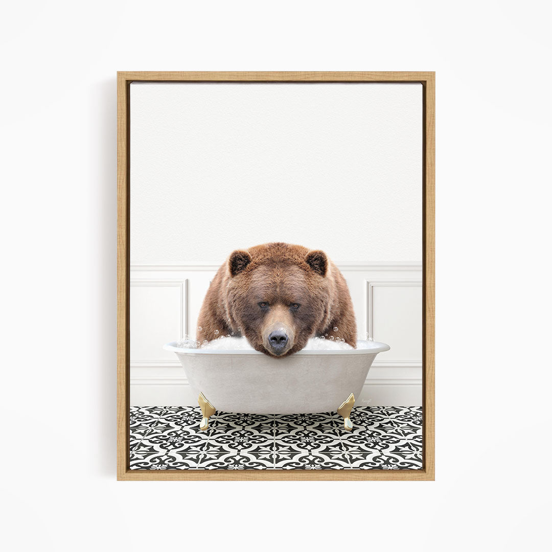 A brown bear is sitting in a white bathtub filled with water, appearing to enjoy the bath.