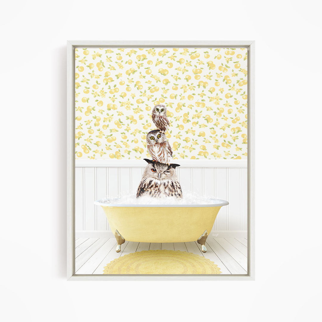 A framed image depicting three owls sitting in a yellow bathtub, with a yellow and white floral wallpaper in the background.