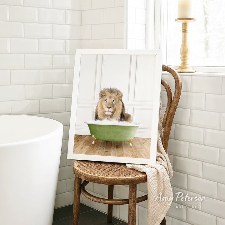 A framed image of a lion sitting in a green bathtub, with a towel draped over the back of the chair.