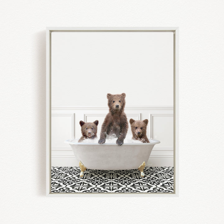 Three adorable brown bears sitting in a white bathtub, with one bear sitting at the center and the other two sitting on either side.