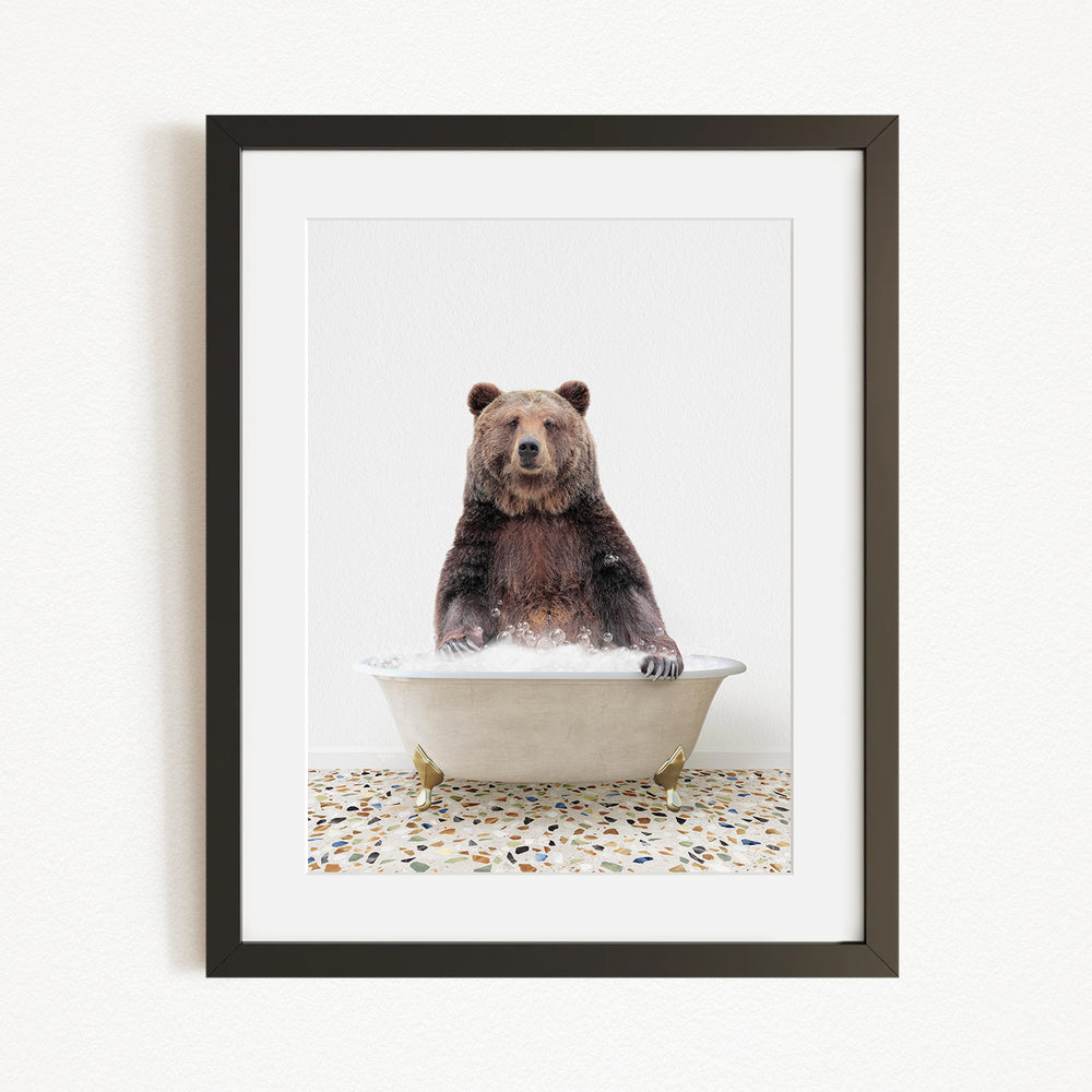 A brown bear sitting in a white bathtub filled with water, creating a whimsical and playful scene.