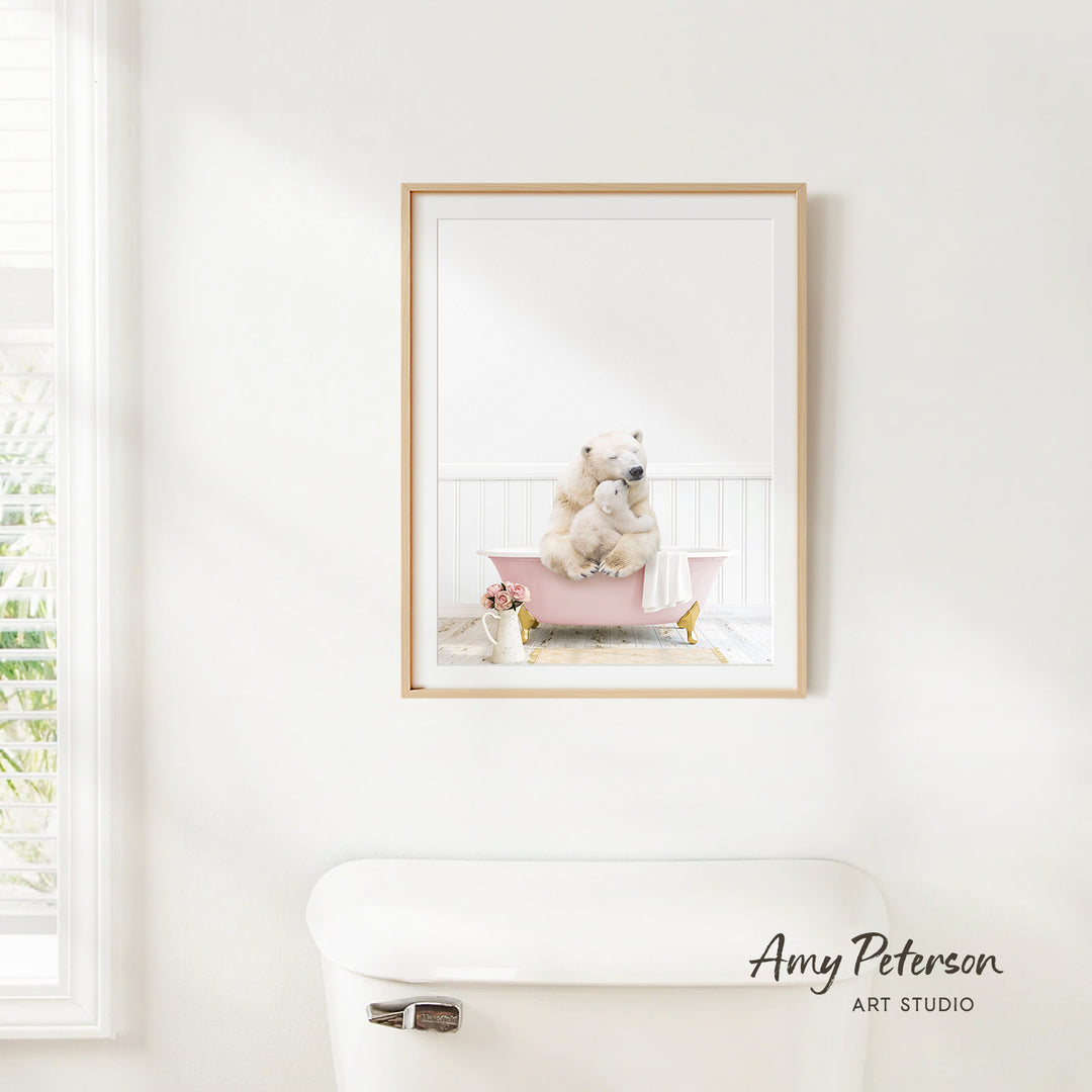 A framed image of a polar bear sitting in a pink bathtub, with a vase of flowers and a white toilet in the foreground.
