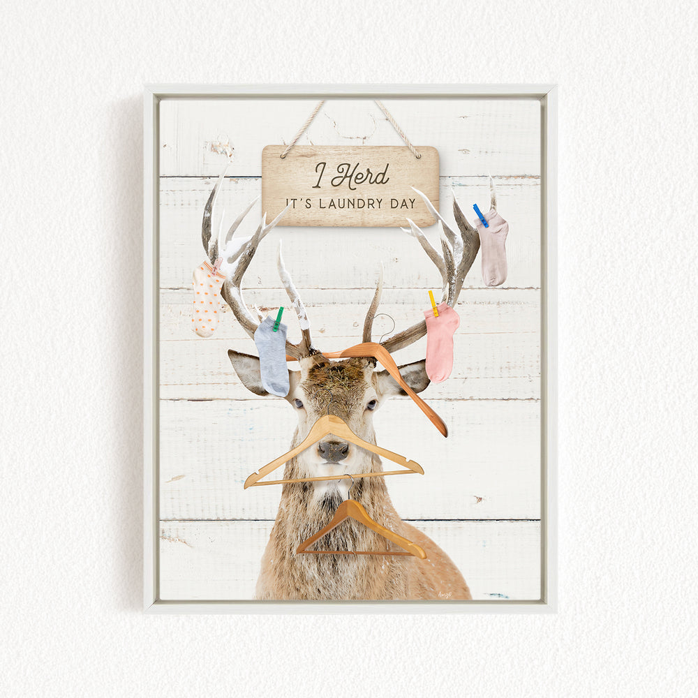 A deer with antlers wearing clothes and socks, with a sign above that says "I herd it's laundry day".