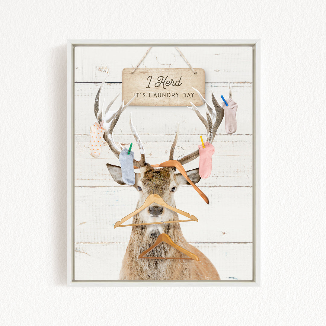 A deer with antlers wearing clothes and socks, with a sign above that says "I herd it's laundry day".