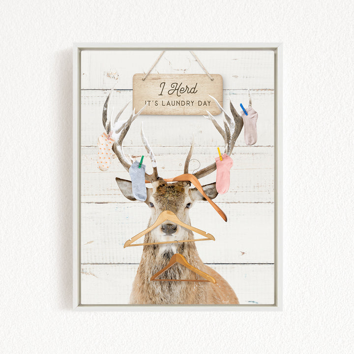 A deer with antlers wearing clothes and socks, with a sign above that says "I herd it's laundry day".