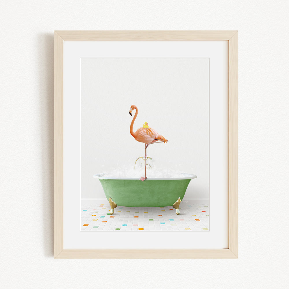 A framed image depicting a pink flamingo standing on a green bathtub filled with water, surrounded by colorful tiles on the floor.