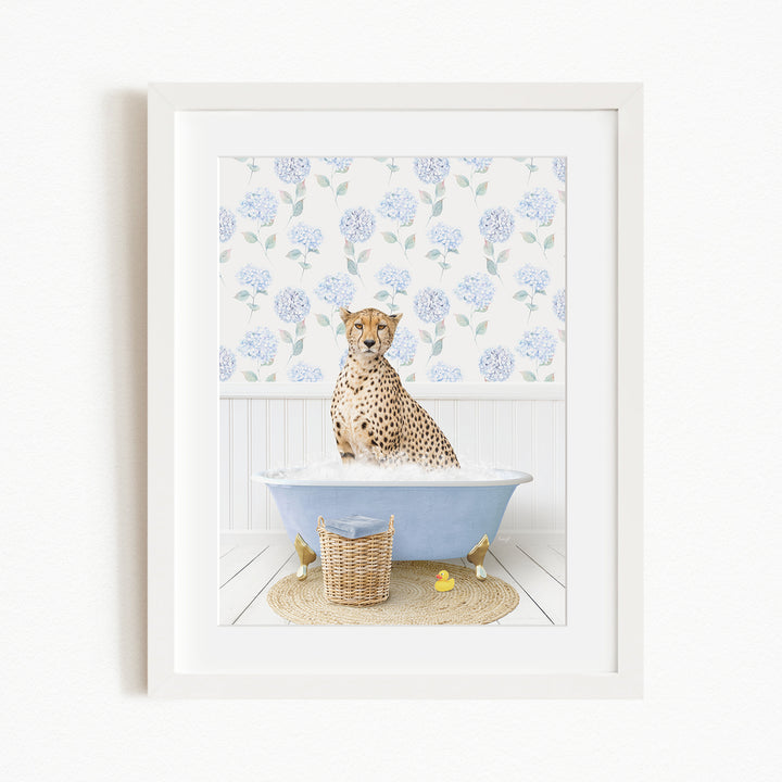 A cheetah sitting in a blue bathtub filled with water, surrounded by a floral patterned wall and a basket of rubber ducks.