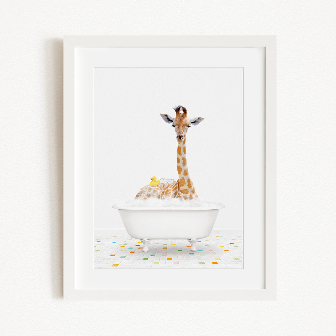 A giraffe sitting in a white bathtub filled with bubbles, with a rubber duck floating nearby.