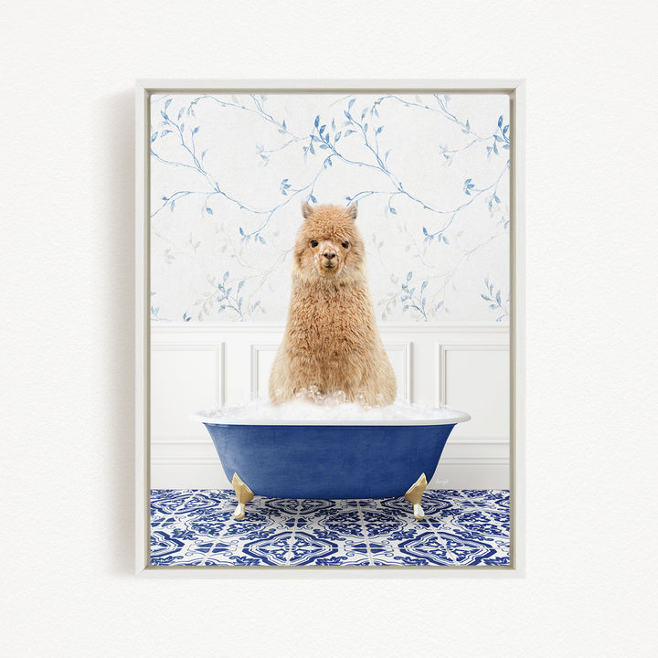 A fluffy brown alpaca sitting in a blue bathtub filled with bubbles, surrounded by a blue and white patterned rug.