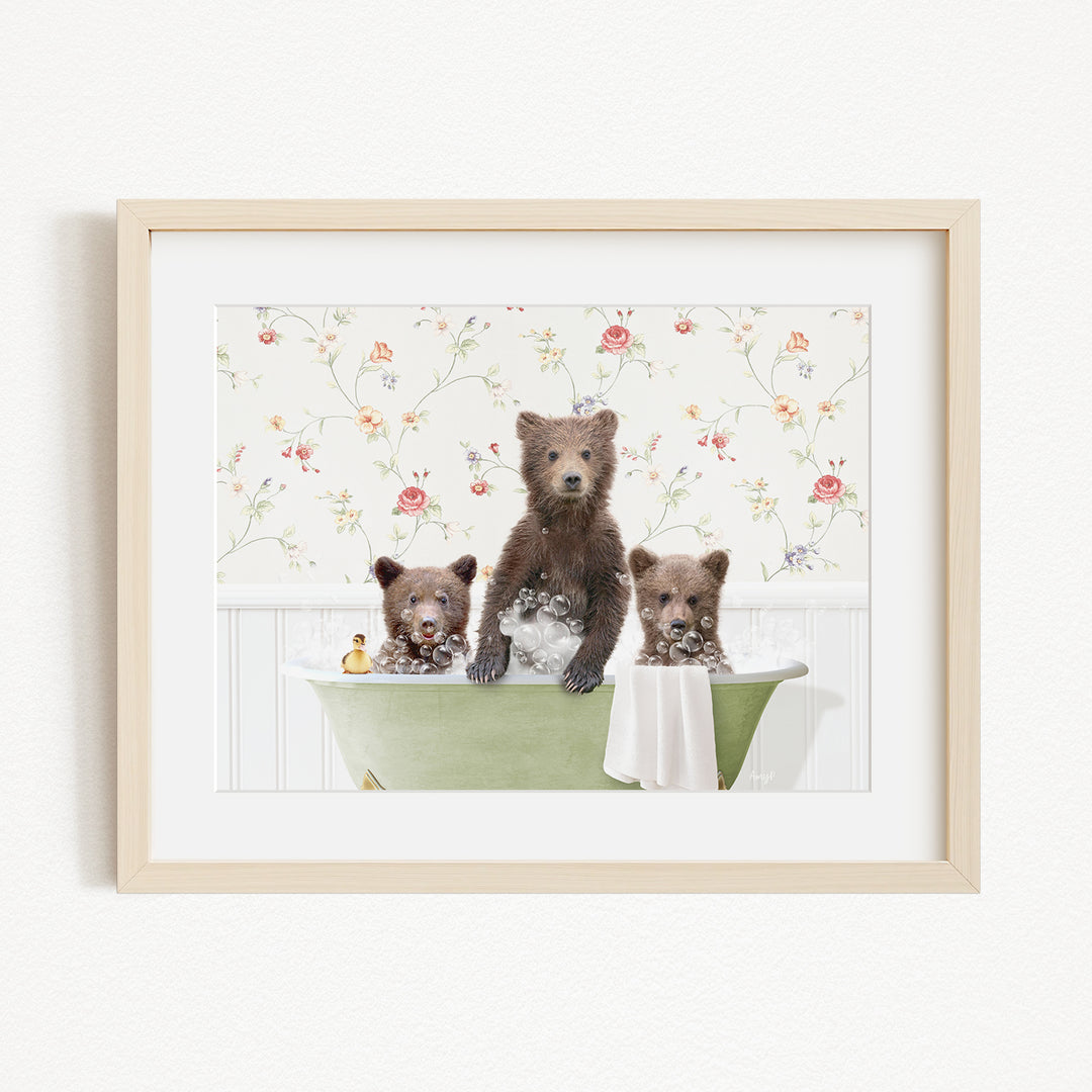 A framed image depicting three bears sitting in a bathtub, with one bear standing and the other two sitting.