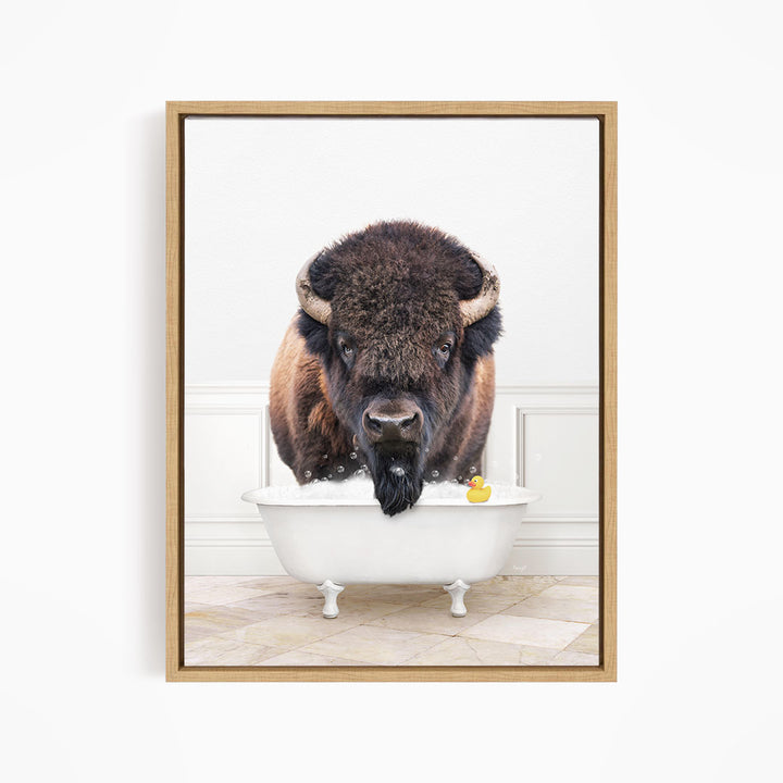 A buffalo with a long beard is sitting in a white bathtub, with a rubber duck floating in the water.
