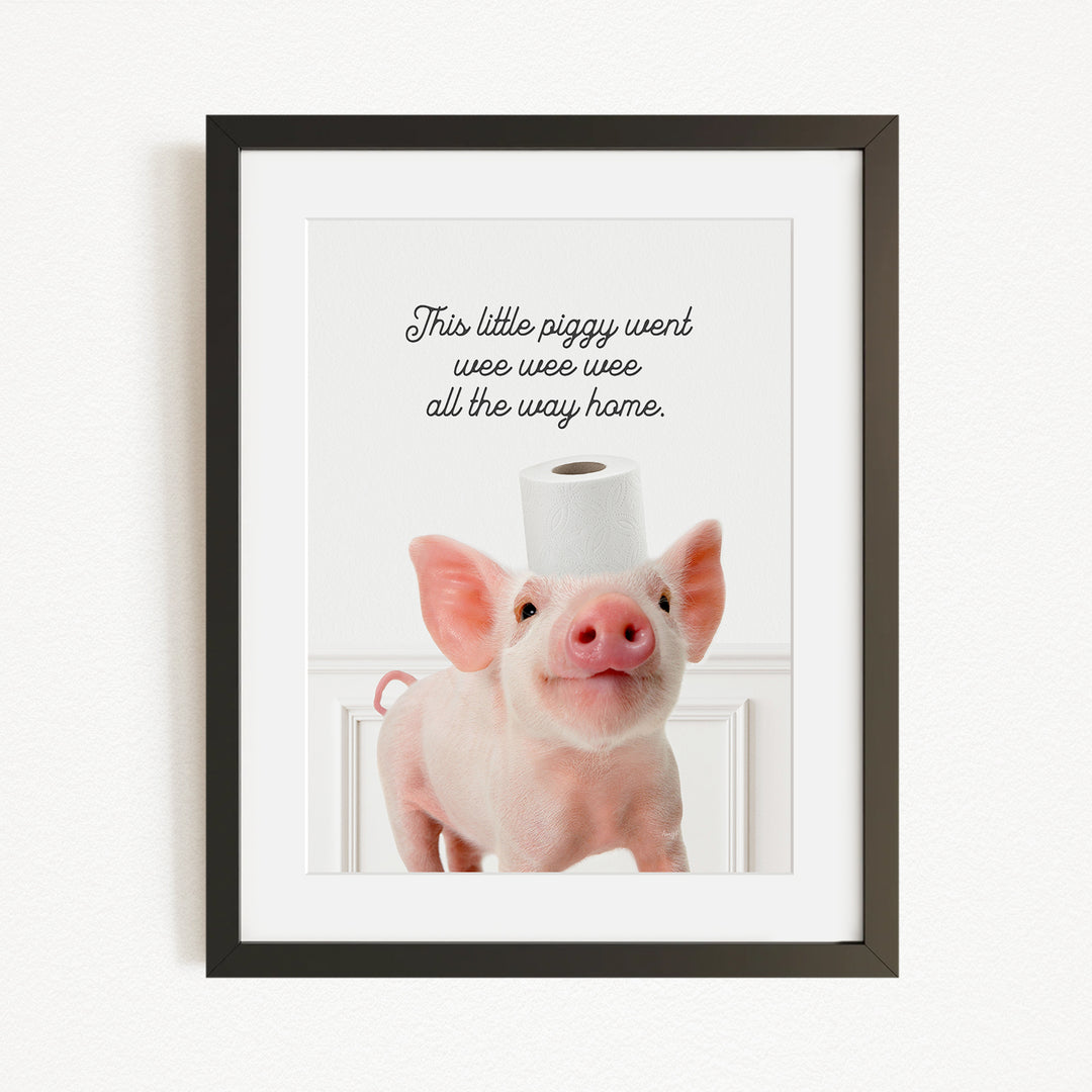 A framed image of a pig with a roll of toilet paper on its head, accompanied by the text "This little piggy went weee weee all the way home."