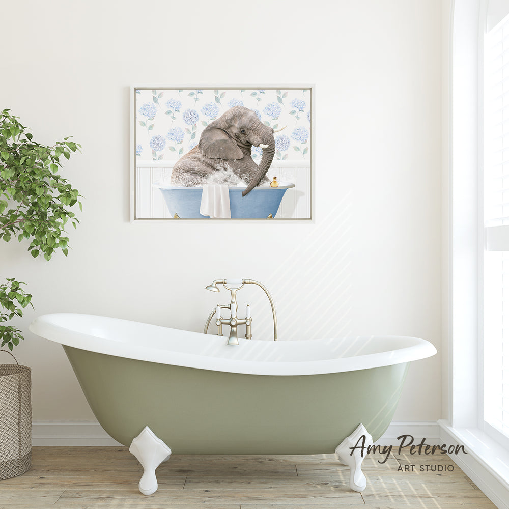 A green clawfoot bathtub with a framed image of an elephant sitting in it, hanging on a white wall above it.
