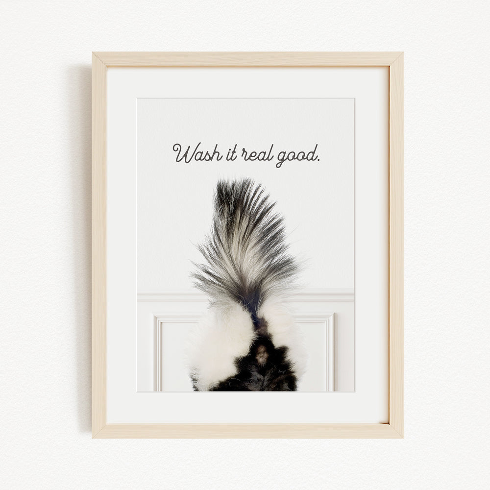 a framed photograph of a skunk's tail with the text "Wash it real good."