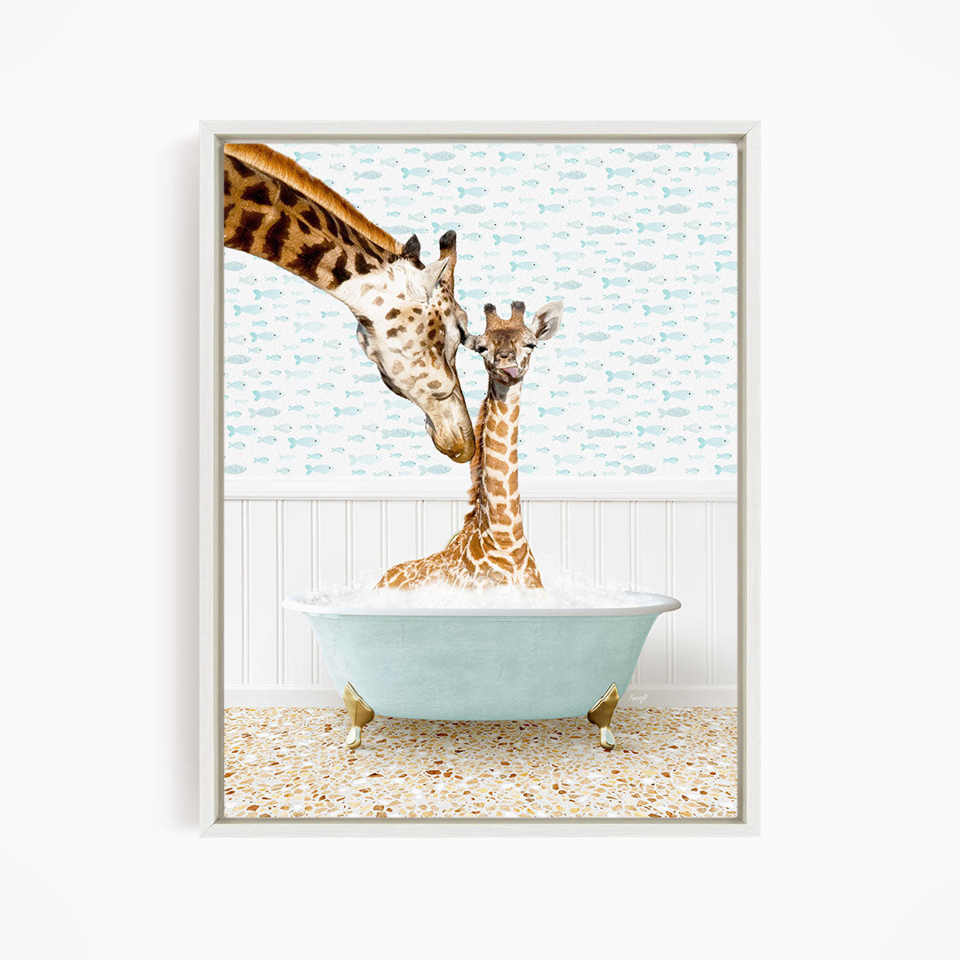 A mother giraffe and her baby giraffe are sitting together in a light blue bathtub, with the mother gently licking her baby.