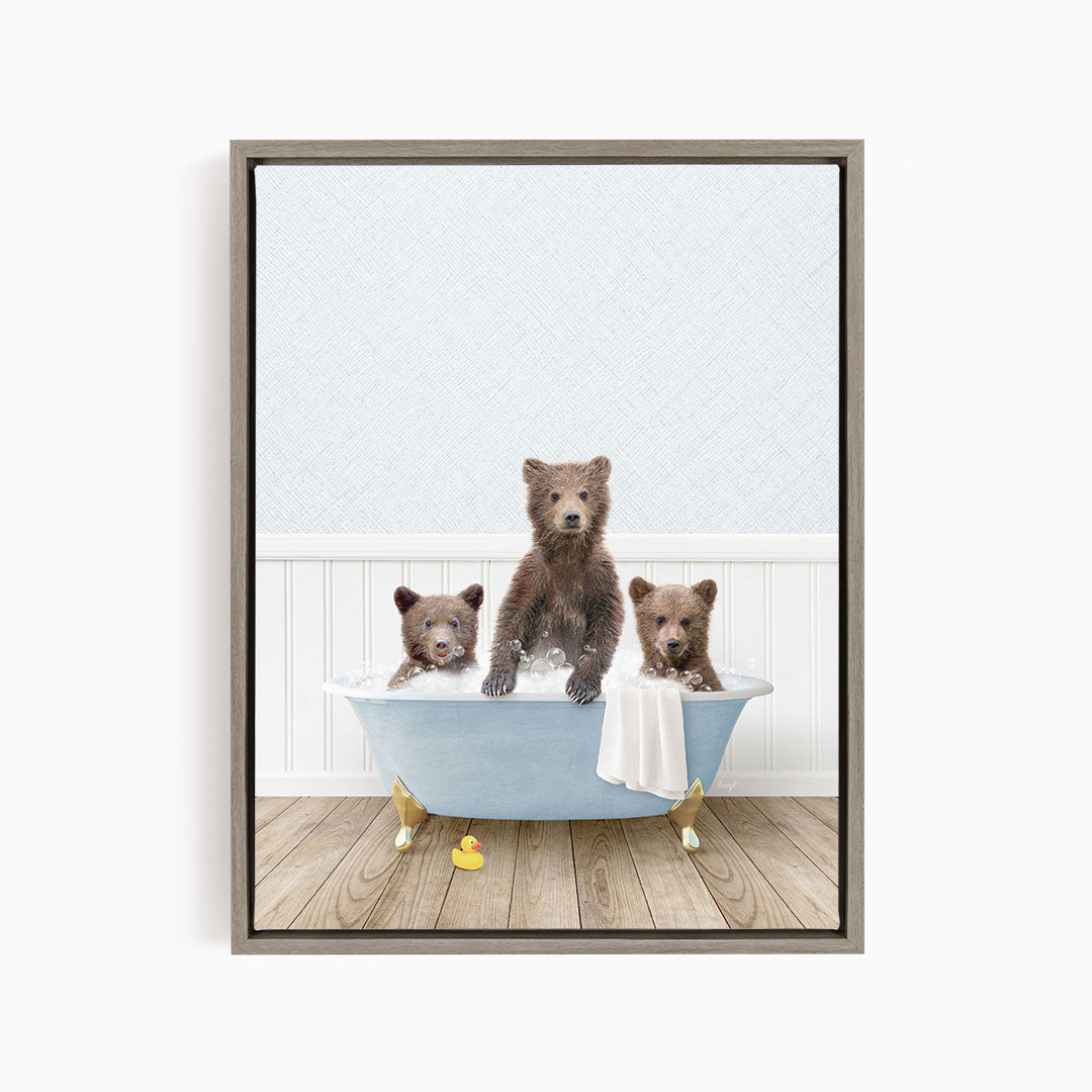 A framed image depicting three brown bears sitting in a blue bathtub, with one bear sitting in the center and the other two bears sitting on either side.