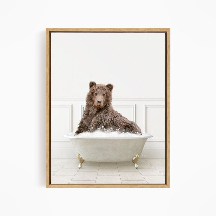 A brown bear sitting in a white bathtub filled with bubbles, looking directly at the camera.