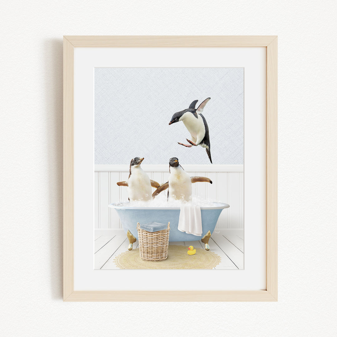 A framed image depicting two penguins sitting in a bathtub, with one penguin flying towards the other.
