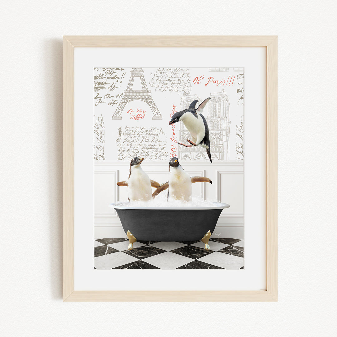 A framed image depicting three penguins sitting in a bathtub, with one penguin jumping out of the tub.