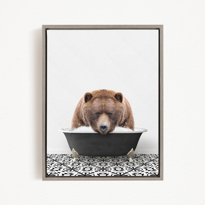 A brown bear is sitting in a black bathtub filled with water, appearing to be enjoying a bath.