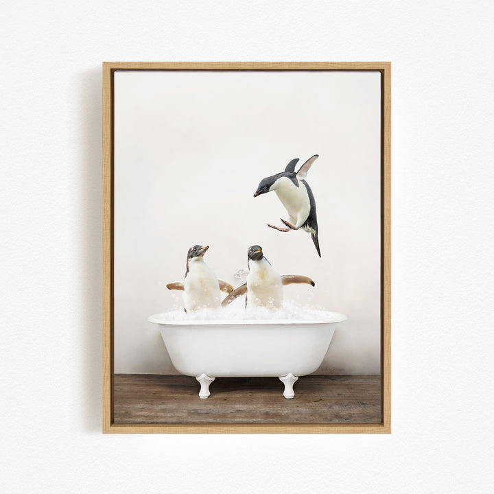 A framed image depicting three penguins in a white bathtub, with one penguin flying above the tub.
