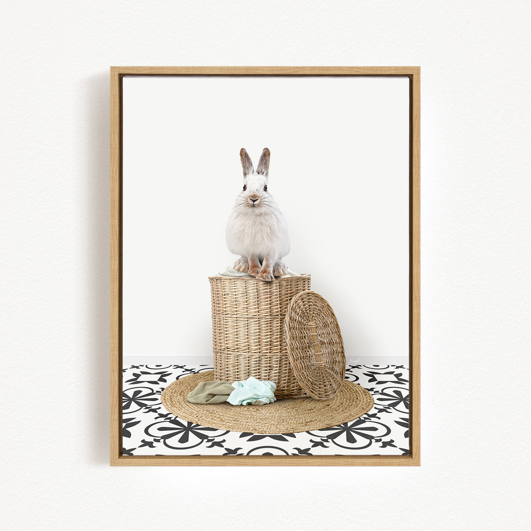 A white rabbit sits atop a woven basket on a patterned rug, with a woven basket and a green cloth nearby.