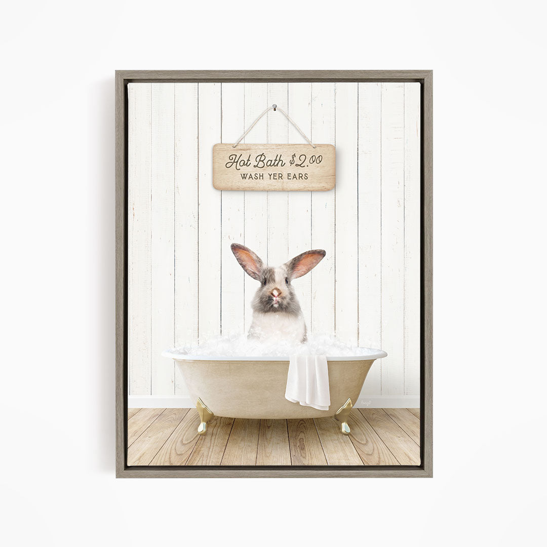 A cute rabbit sitting in a bathtub filled with water, with a sign above that reads "Hot Bath $2.00 WASH EARS".