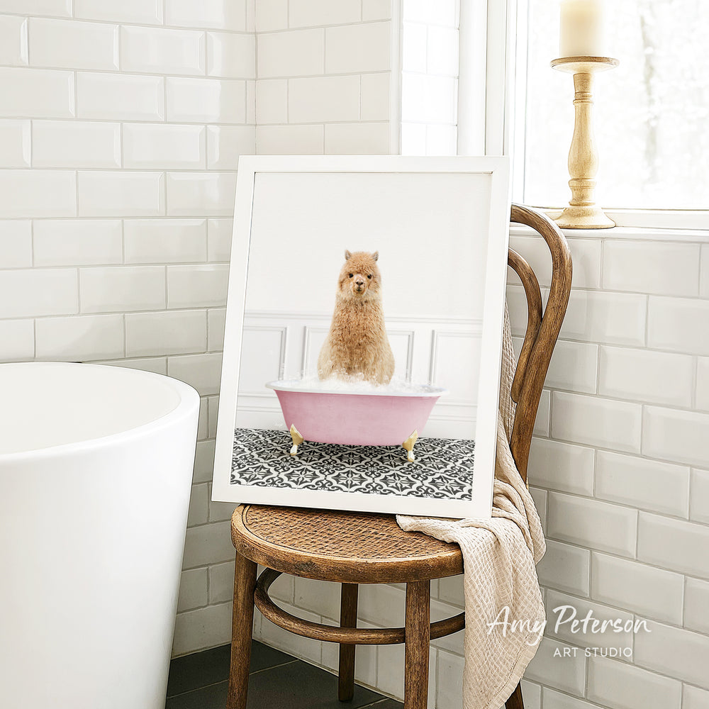 A framed image of a small dog sitting in a pink bathtub, with a towel draped over the back of a wooden chair in the background.