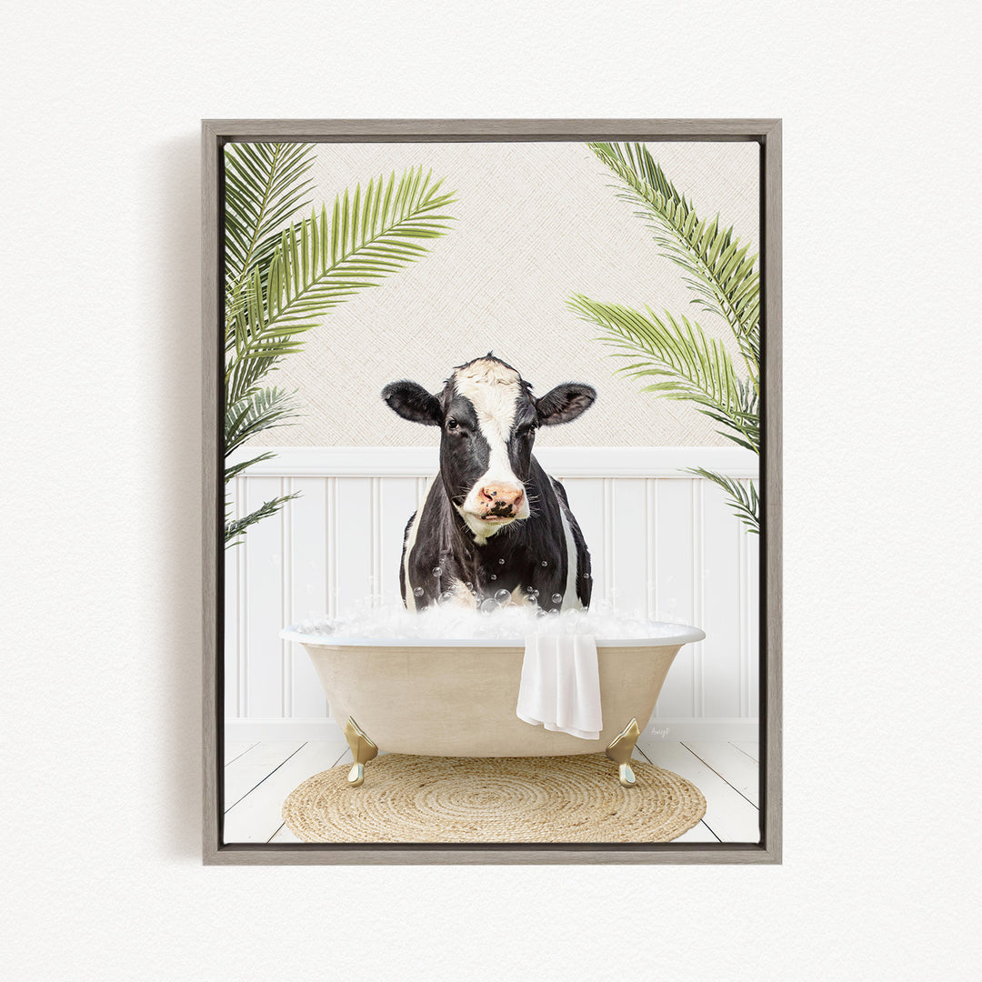 A black and white cow is sitting in a bathtub filled with water, surrounded by green palm leaves.