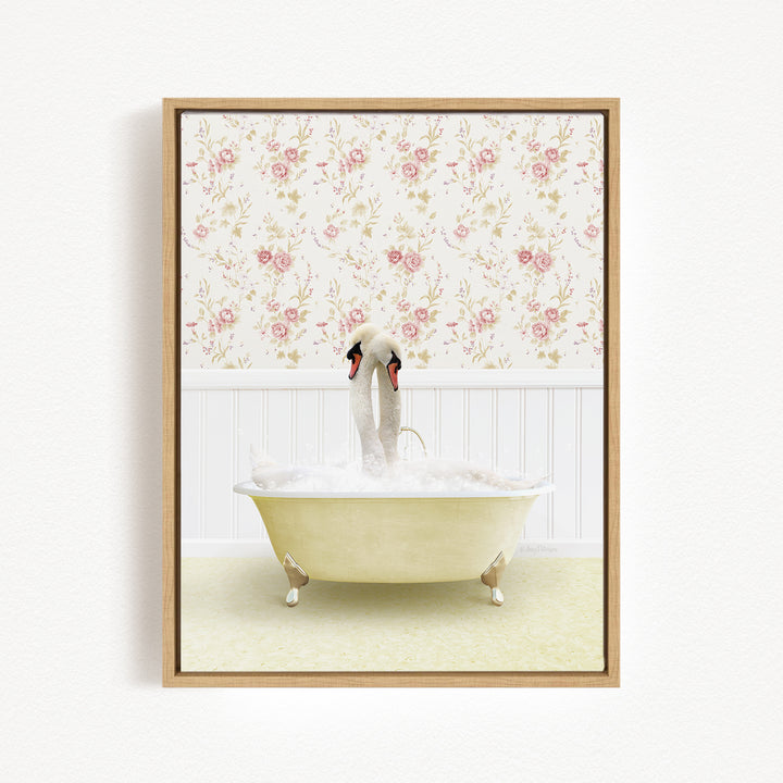 A framed image depicting two swans sitting in a bathtub filled with bubbles, with a floral wallpaper in the background.