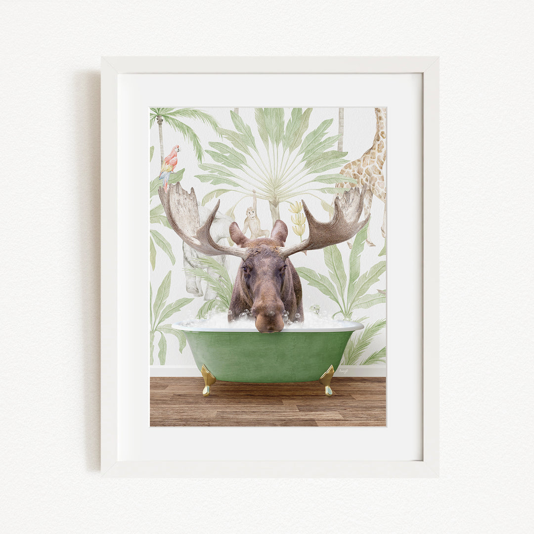 A moose with large antlers is sitting in a green bathtub, surrounded by a tropical wallpaper with palm leaves and a giraffe.