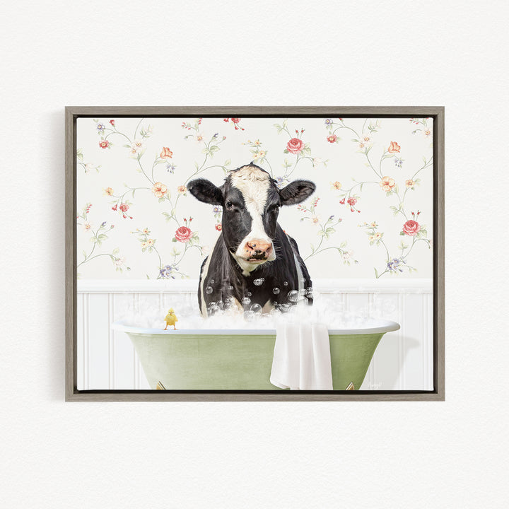 A black and white cow is sitting in a green bathtub filled with bubbles, with a yellow bird perched on the edge of the tub.