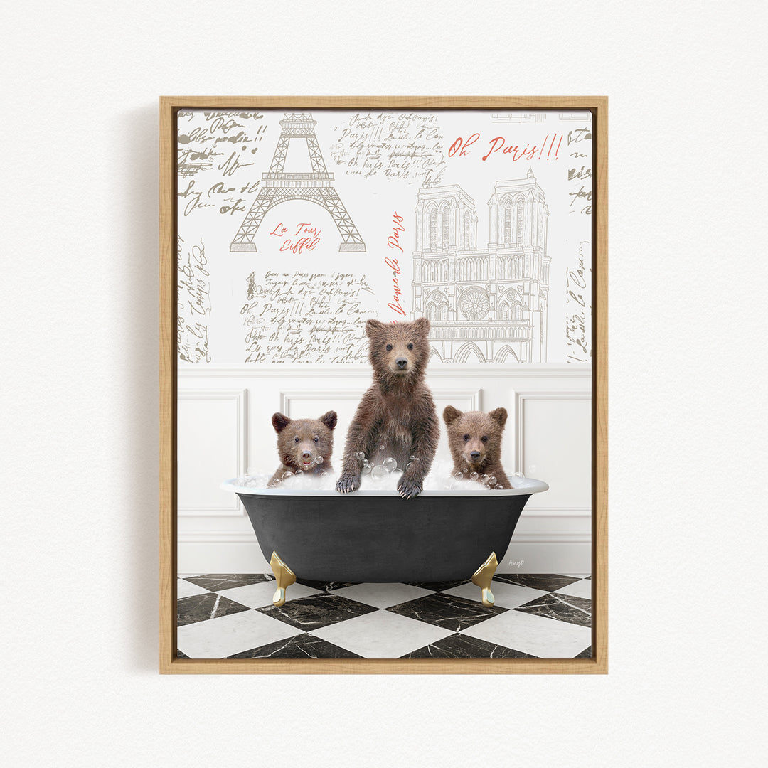 A framed image depicting three bears sitting in a bathtub, with a drawing of the Eiffel Tower in the background.