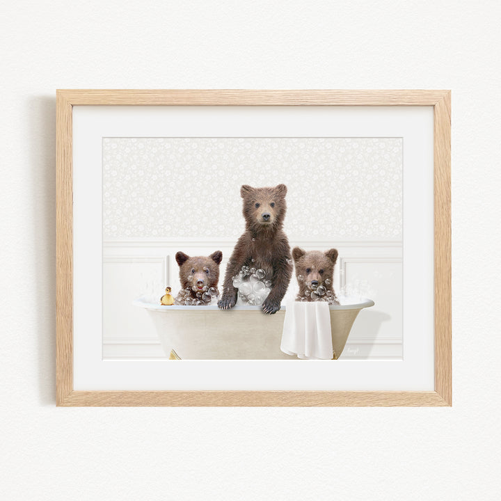 A framed image depicting three bears sitting in a bathtub, with one bear sitting on the edge of the tub and the other two bears sitting inside the tub.